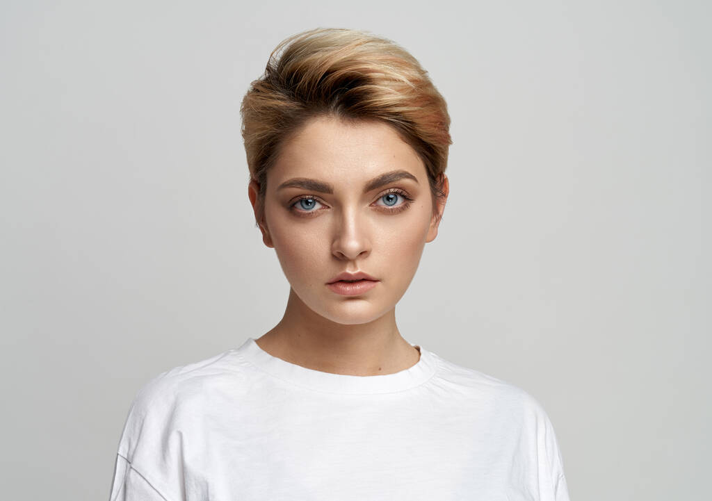 Portrét mladé ženy model s krátkými vlasy izolované na šedém pozadí - Fotografie, Obrázek
