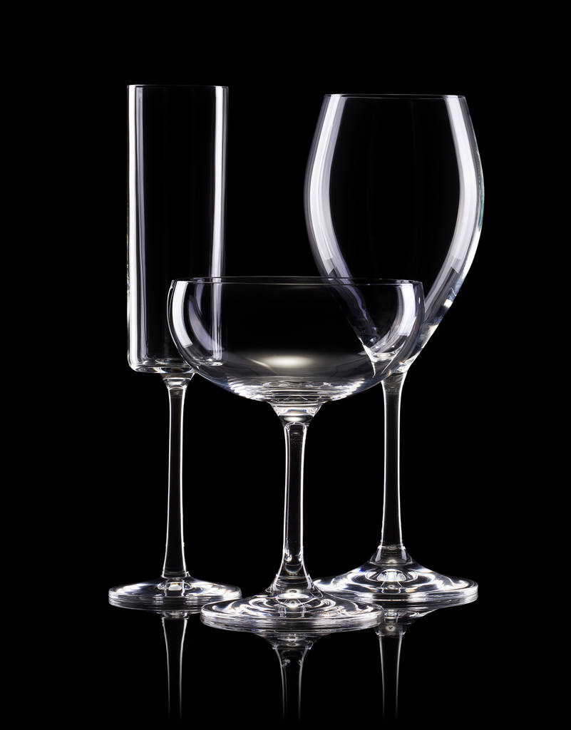 Set van verschillende lege glazen voor drankjes op zwarte achtergrond - Foto, afbeelding