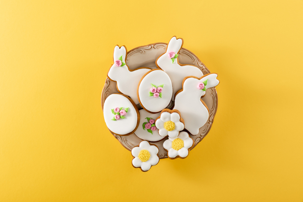 Top view of bowl with tasty easter cookies on yellow background - Photo, Image