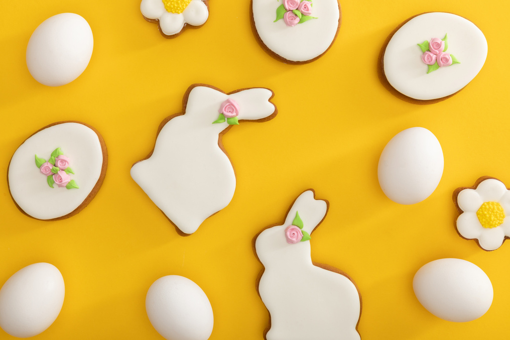 Top view of tasty easter cookies and chicken eggs on yellow background - Fotografie, Obrázek