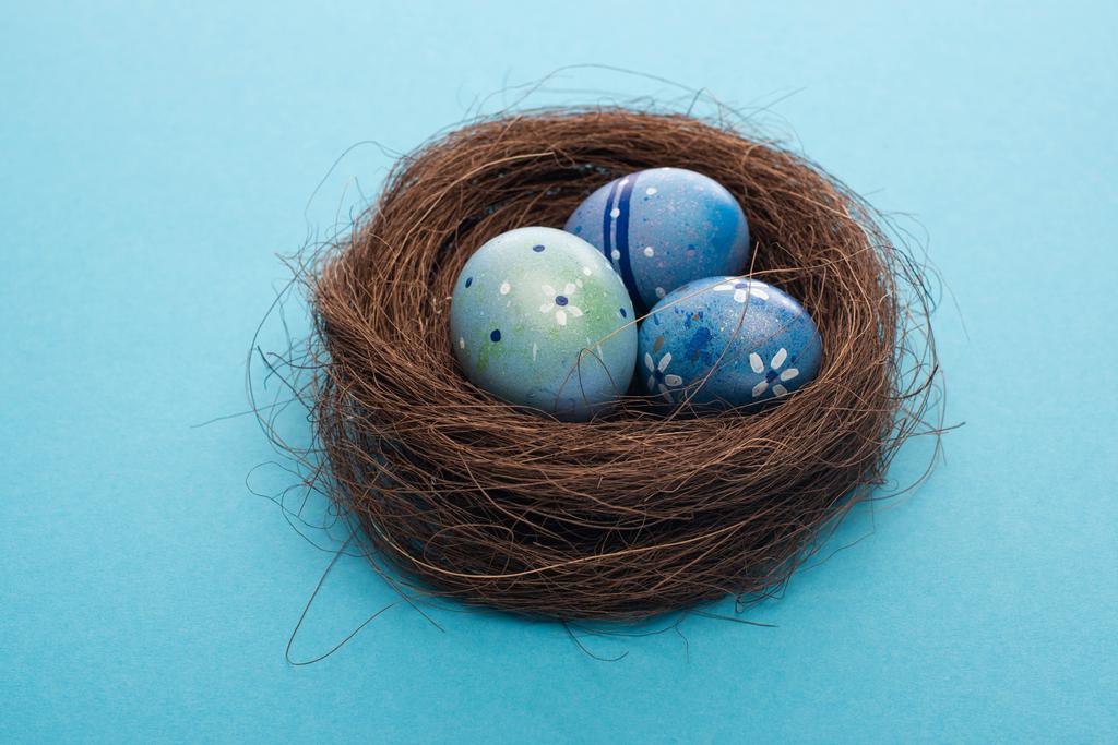 Close-up zicht op paaseieren in nest op blauw  - Foto, afbeelding