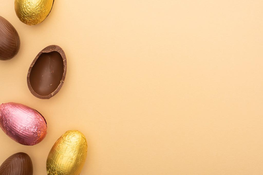 Top view of delicious chocolate eggs on beige background - Photo, Image