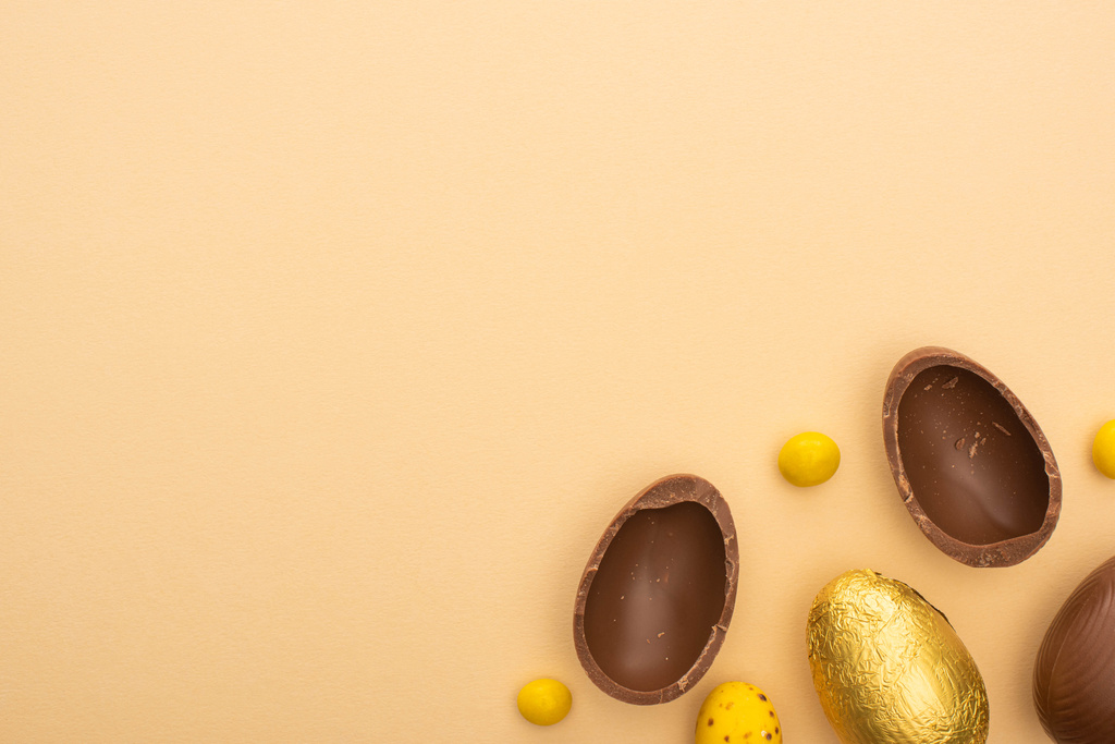Top näkymä suklaa ja viiriäisen munia keltainen makeisia beige tausta
 - Valokuva, kuva