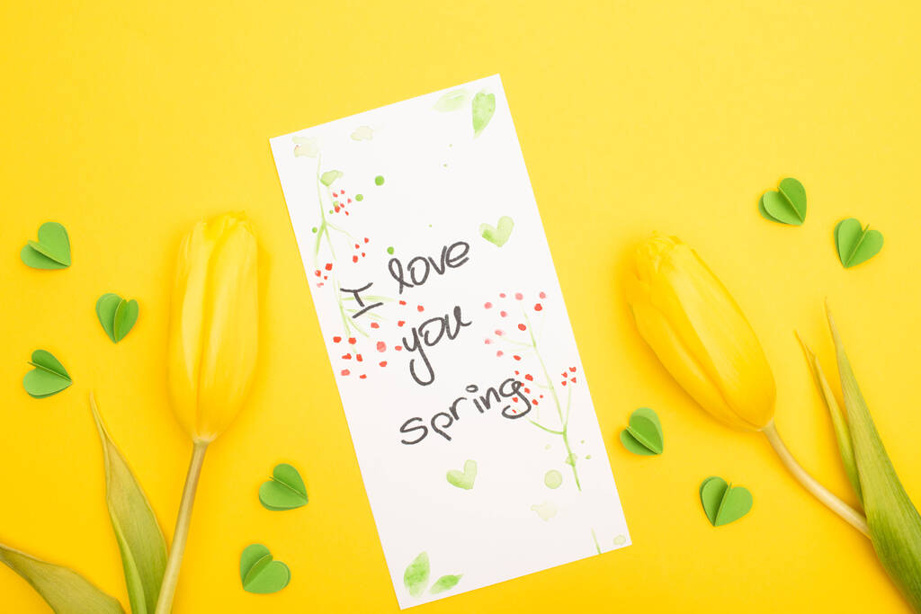 Vista superior de tulipanes, tarjeta con I love you letras de primavera y corazones decorativos sobre fondo amarillo
 - Foto, Imagen