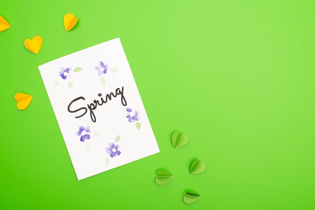 Top näkymä kortin keväällä kirjaimet ja koriste sydämet vihreällä taustalla
 - Valokuva, kuva