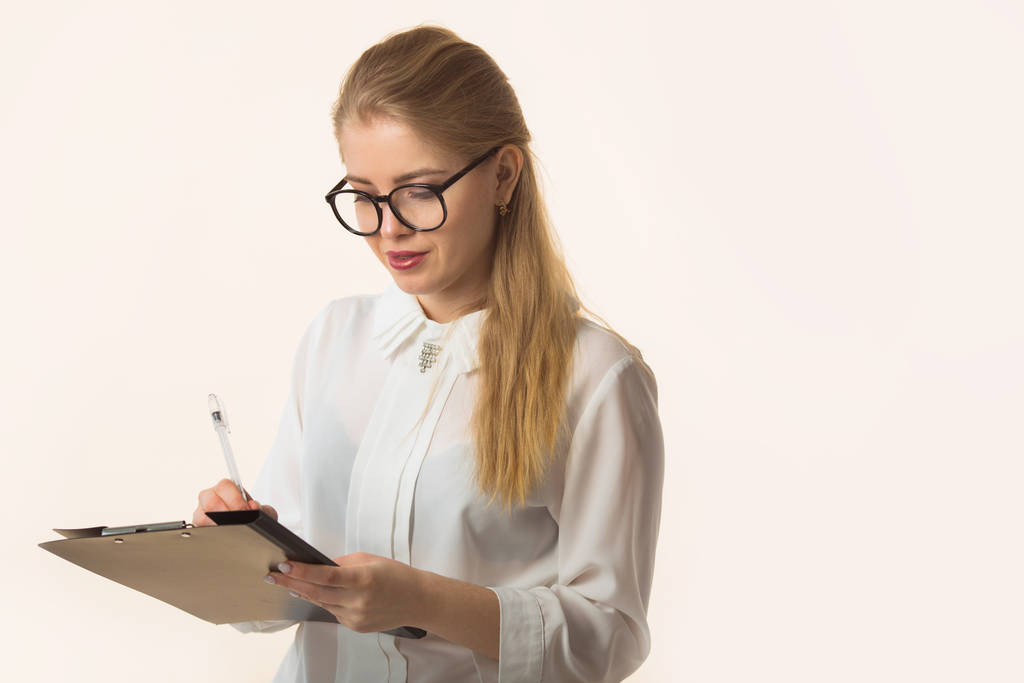 bella giovane donna in camicia su sfondo bianco con un blocco note notebook
 - Foto, immagini