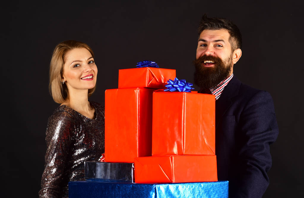Couple in love holds stack of presents on black background - Photo, Image