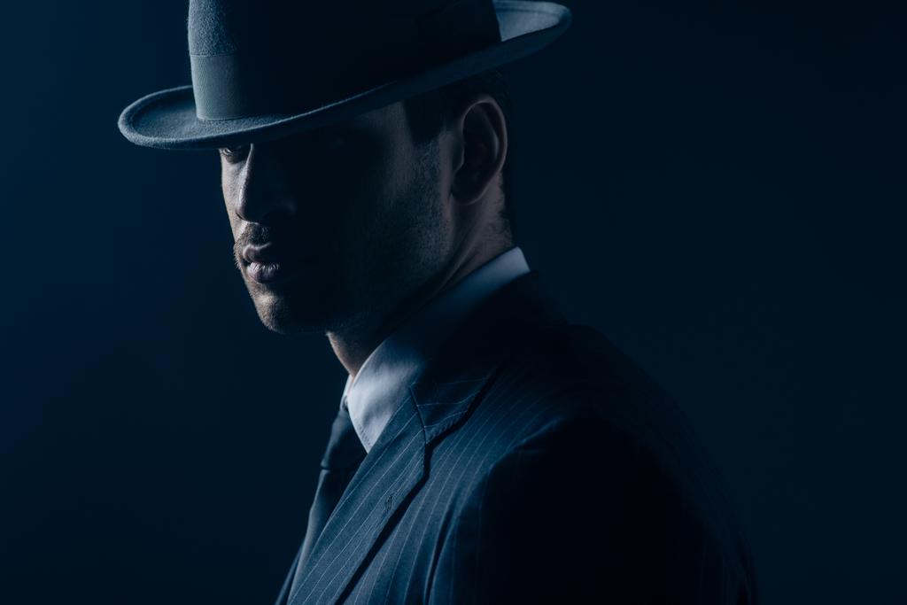 Portrait de mafieux en feutre chapeau et costume sur fond bleu foncé
 - Photo, image
