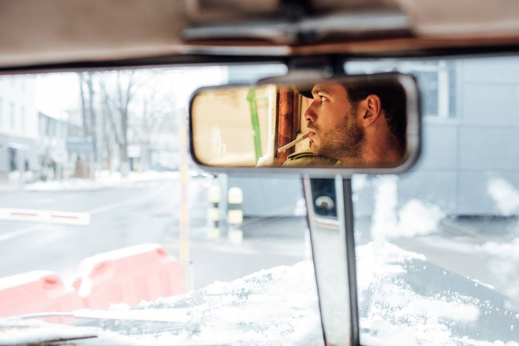 Выборочный фокус отражения мафиози в зеркале заднего вида, курение в автомобиле
 - Фото, изображение