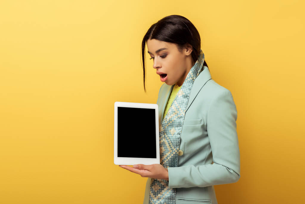 chocado Africano americano mulher segurando tablet digital com tela em branco no amarelo  - Foto, Imagem