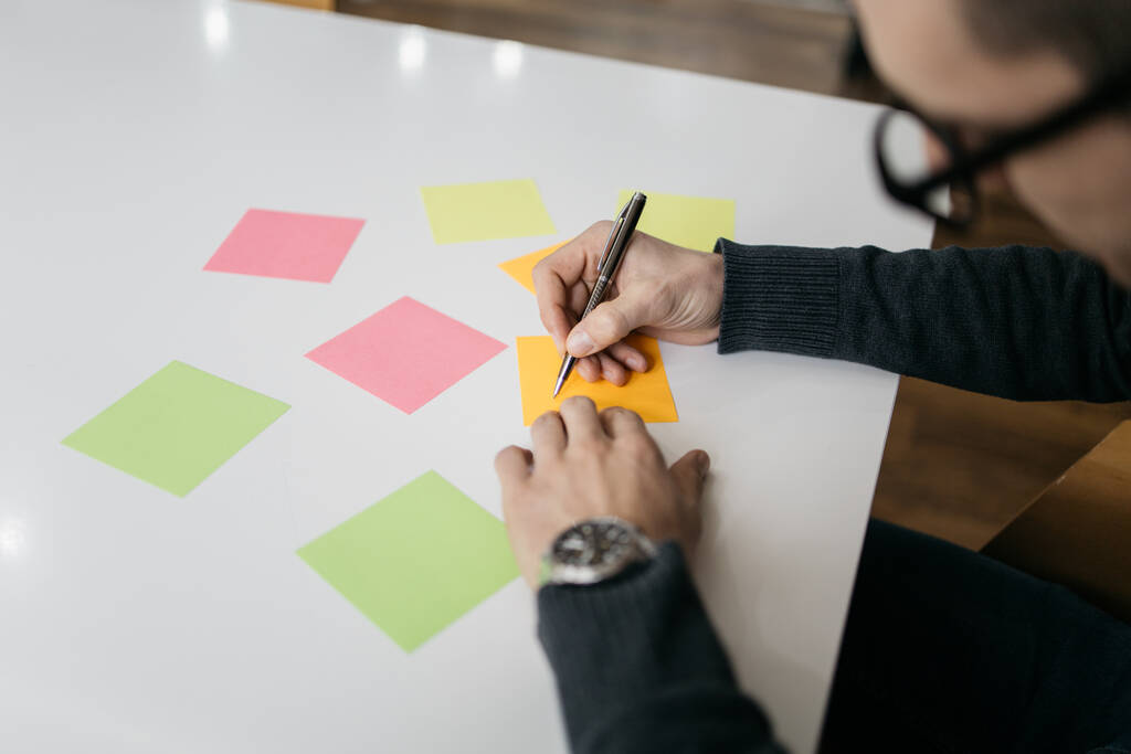 Close-up view of man writing on sticky notes - Photo, Image
