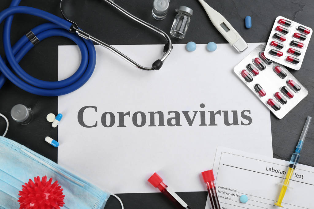 単語CORONAVIRUSとフラットレイ組成物,黒いテーブルの上の聴診器と薬 - 写真・画像