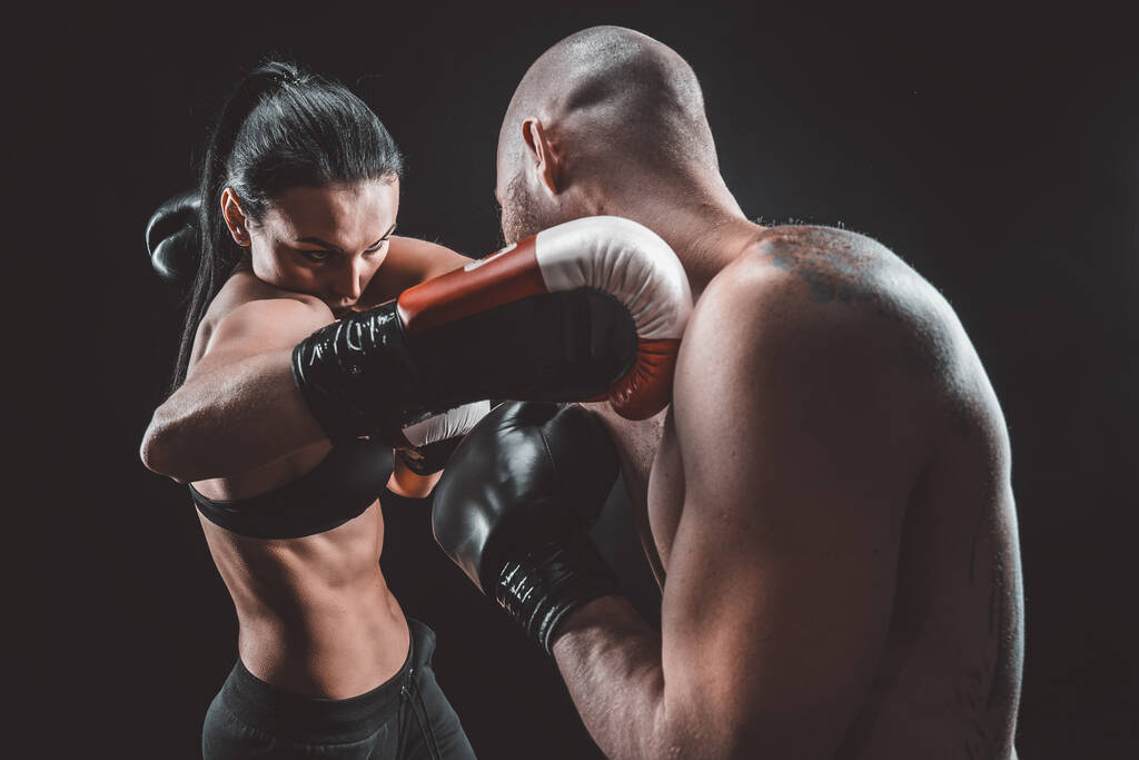 Shirtless Woman exercitando-se com o treinador na aula de boxe e autodefesa, estúdio, fumaça no fundo. Feminino e masculino luta - Foto, Imagem