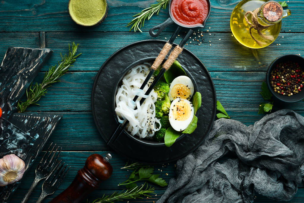 Rice noodles with egg, broccoli and spinach. Asian cuisine. Top view. Free space for your text. - Photo, Image