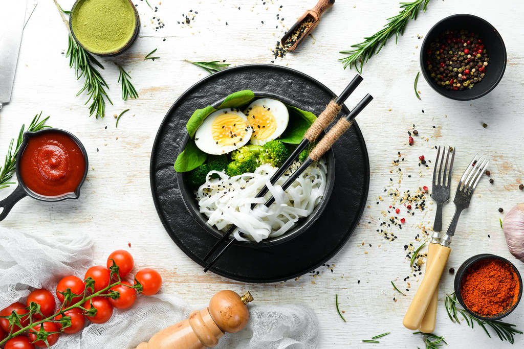 Fideos de arroz con huevo, brócoli y espinacas. Cocina asiática. Vista superior. Espacio libre para tu texto
. - Foto, imagen