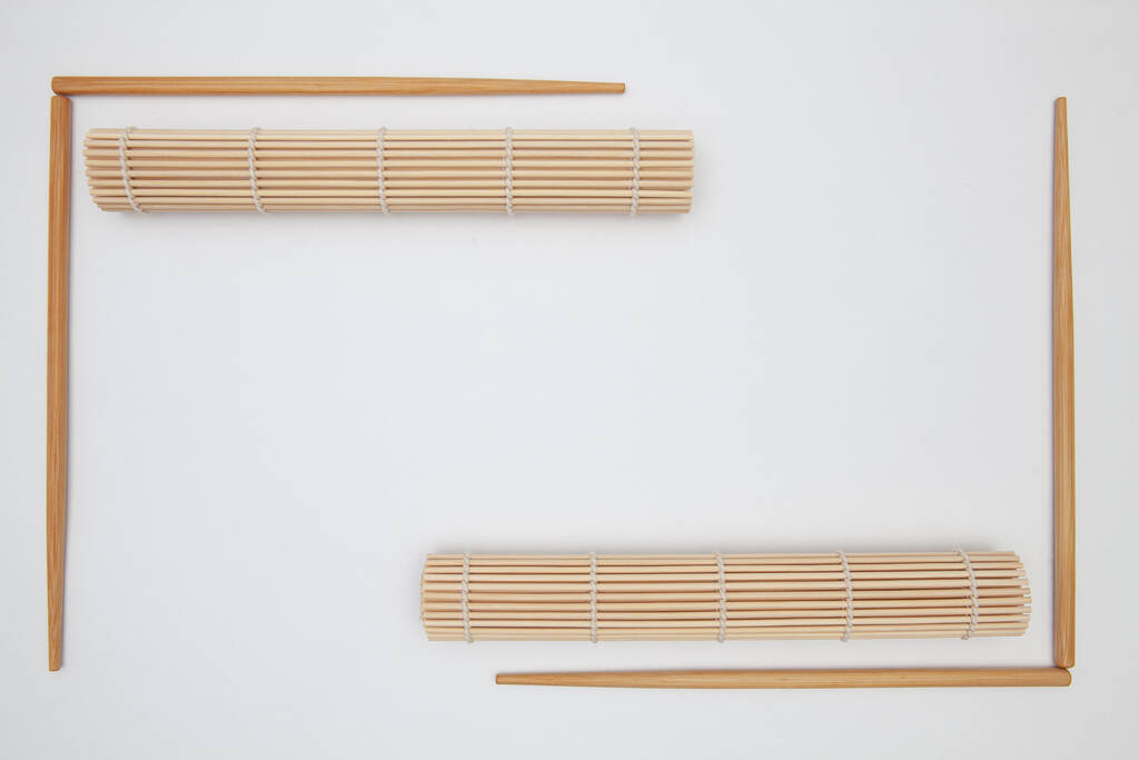 Bambumatto syömäpuikoilla sushia valkoisella pöydällä. Elintarvikkeiden suunnittelu
 - Valokuva, kuva