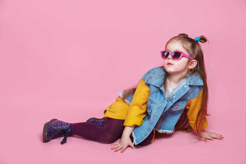 modna dziewczynka w okularach przeciwsłonecznych pozowanie na różowym tle - Zdjęcie, obraz