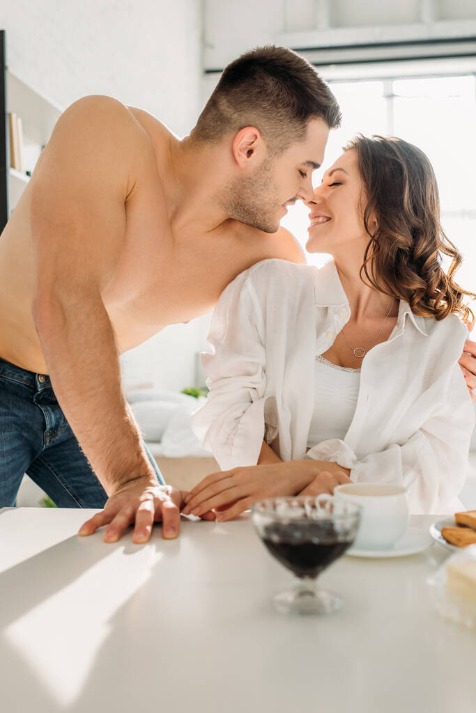selective focus of happy couple near kitchen table with breakfast - Photo, Image
