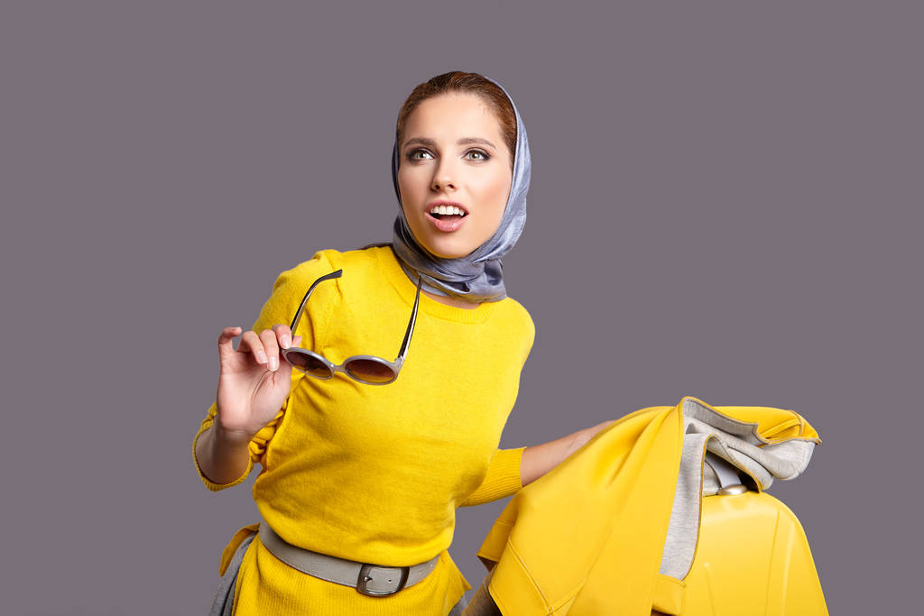 Retrato de jovem mulher vestindo xale de pé com saco de viagem amarelo
 - Foto, Imagem