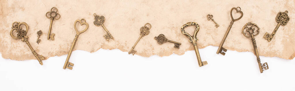 вид сверху на старинные ключи на бумаге, изолированные на белом, панорамный снимок
 - Фото, изображение