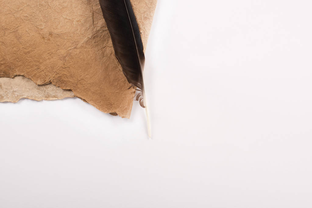 vrchní pohled na starodávný papír a peří izolované na bílém - Fotografie, Obrázek