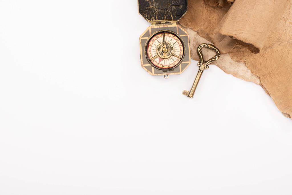 верхний вид винтажного ключа, компас и старая бумага изолированы на белом
 - Фото, изображение