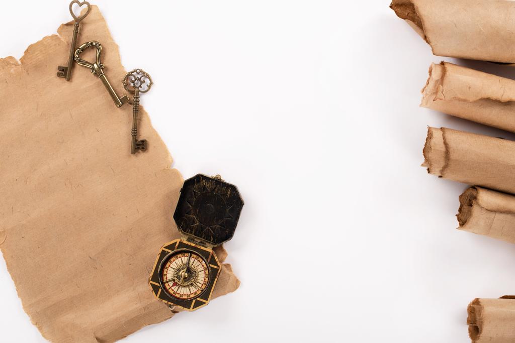 ylhäältä näkymä vintage kompassi, avaimet ja vuotiaiden pergamentti paperi eristetty valkoinen
 - Valokuva, kuva