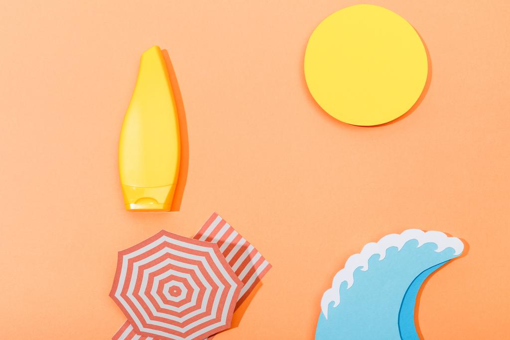 Вид сверху на вырезанный из бумаги пляж с трубкой солнцезащитного крема на оранжевом фоне
 - Фото, изображение