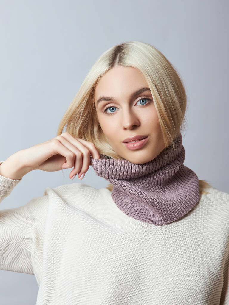 Piękna blondynka z szalikiem na szyi. Dziewczyna w wiosennych ubraniach, ciepły sweter - Zdjęcie, obraz