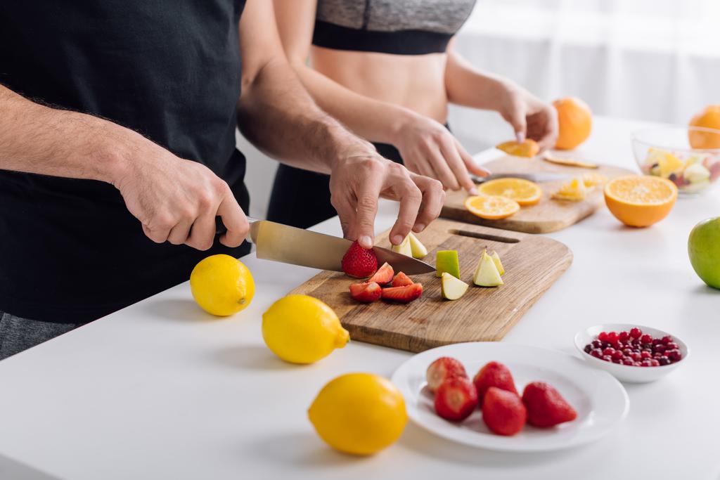 Ausgeschnittene Ansicht von Mann und Frau bei der Zubereitung von Obstsalat  - Foto, Bild