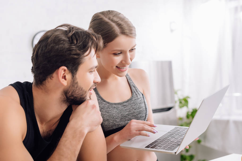 幸せな男と女は家でノートパソコンを見て  - 写真・画像