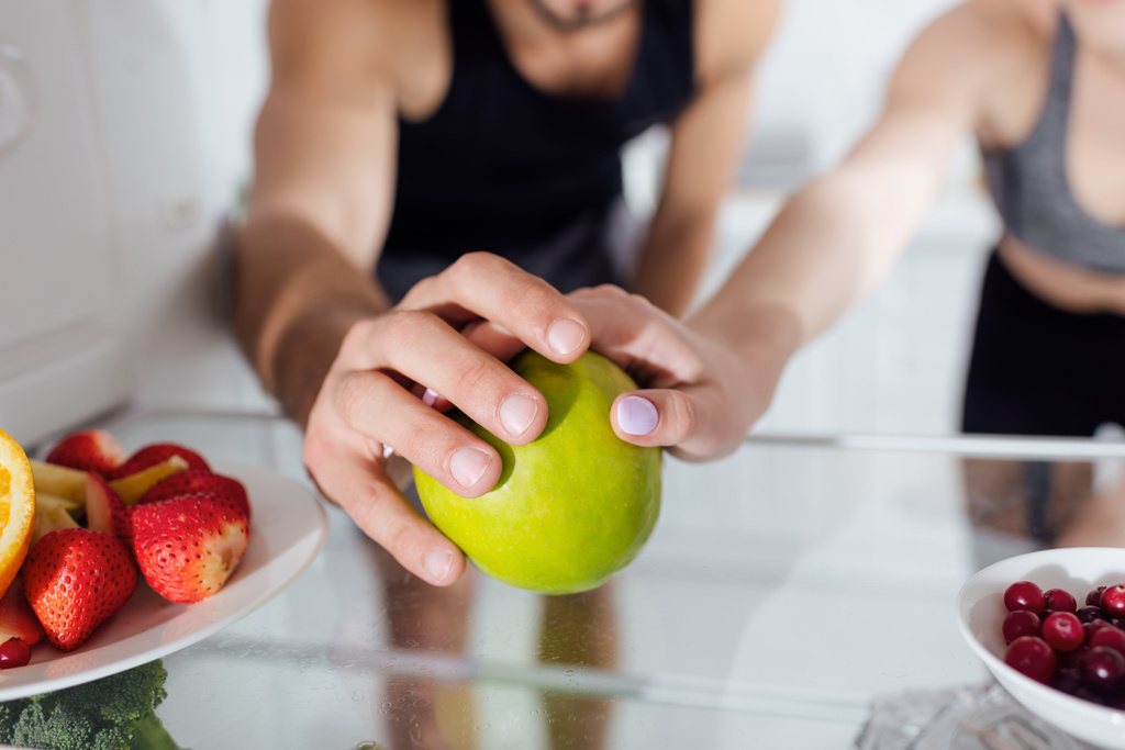 levágott kilátás férfi és nő megható alma a hűtőben  - Fotó, kép