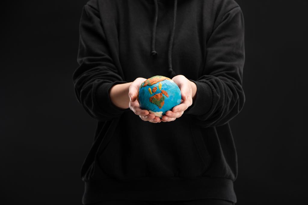 Частковий погляд на жінку, що тримає пластмасовий глобус ізольований на чорному, глобальному потеплінні концепції
 - Фото, зображення