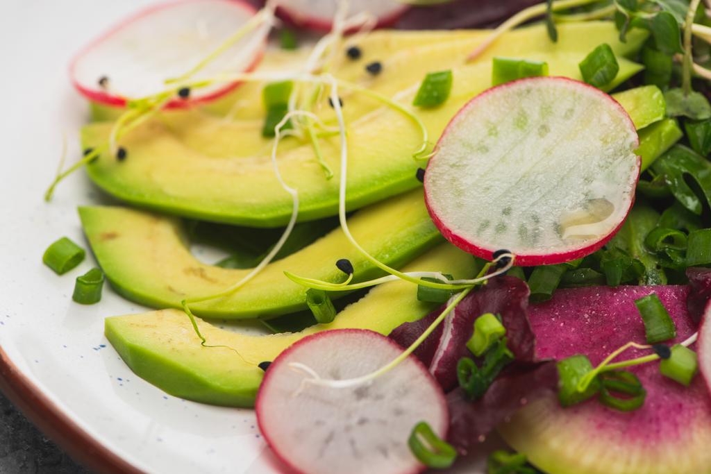 крупним планом свіжий салат з редькою з зеленню та авокадо
 - Фото, зображення
