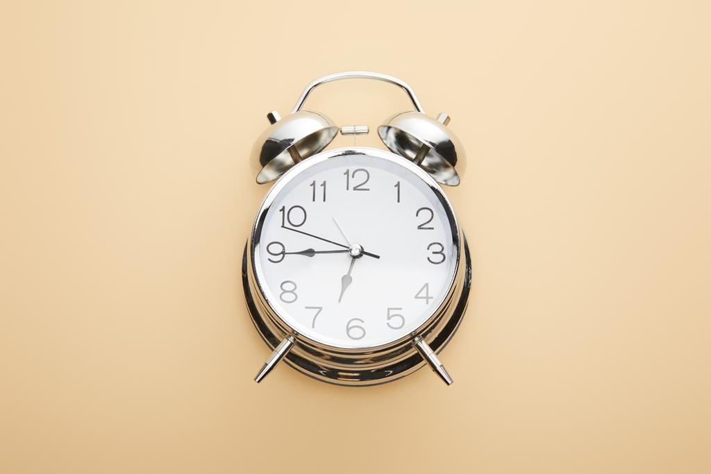 vista superior del reloj despertador clásico sobre fondo beige
 - Foto, Imagen