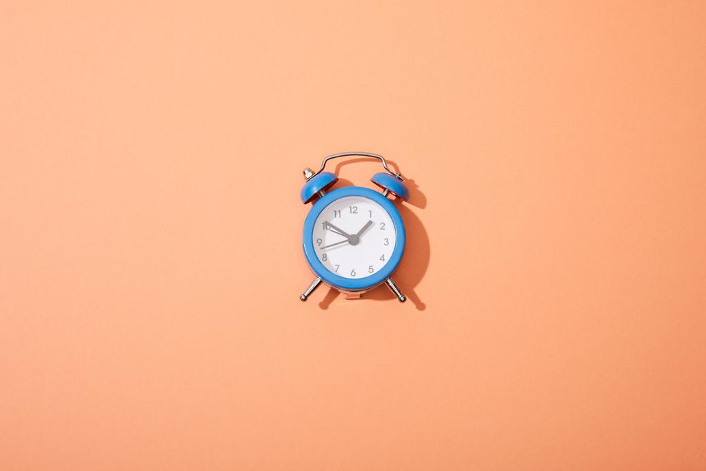 top view of classic alarm clock on peach background - Photo, Image