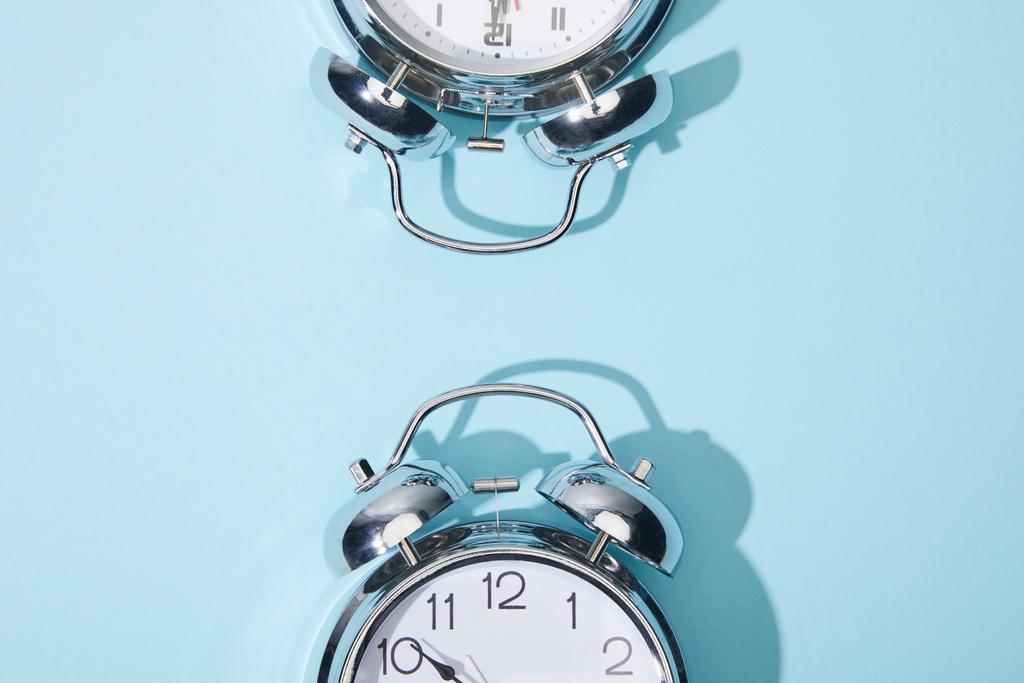 top view of classic alarm clocks on blue background - Photo, Image