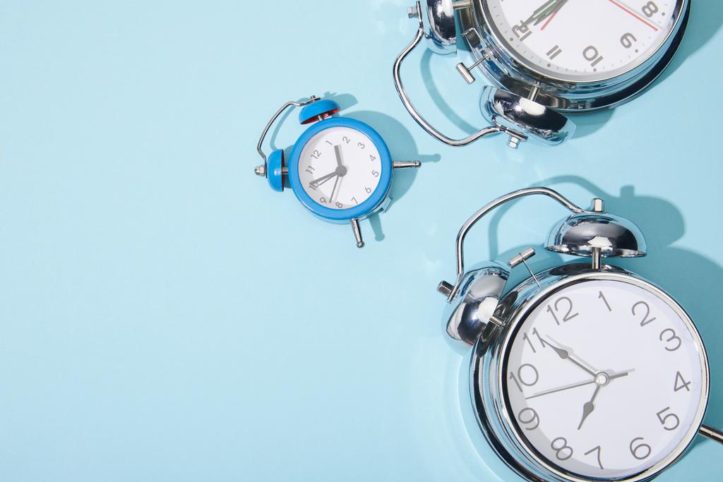 vista superior de los relojes de alarma clásicos sobre fondo azul
 - Foto, Imagen