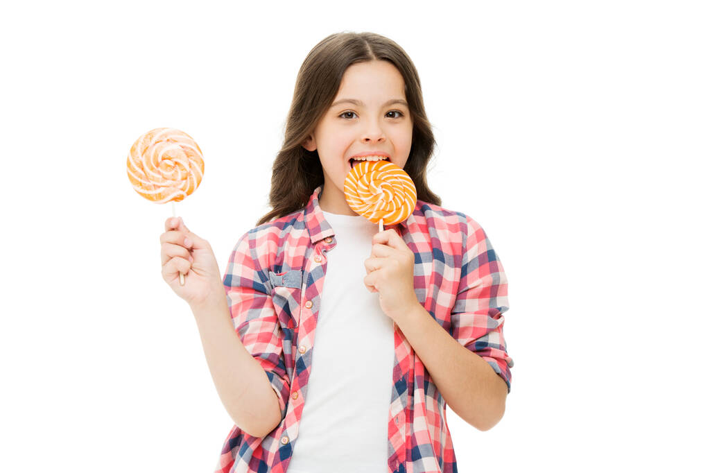 Lollipop a day helps you rest and play. Happy girl enjoy lollipop isolated on white. Small child lick lollipop. Enjoying colorful swirl lollipop on stick. Unhealthy eating. Sweet treat. Candy shop - Photo, Image