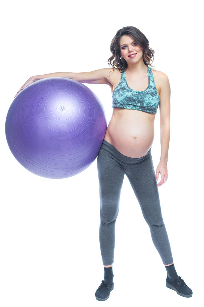 Ritratto di una bella giovane donna incinta esercizi con fitball. Allenamento e fitness, concetto di gravidanza. Isolato sfondo bianco
. - Foto, immagini