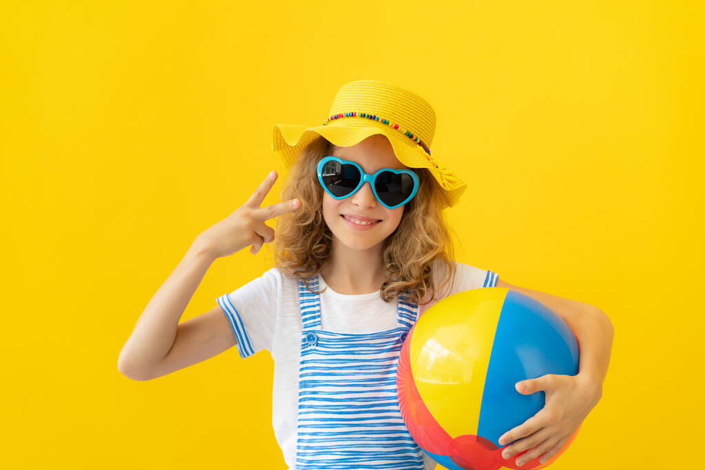 Portrét šťastného dítěte na žlutém pozadí. Holka se baví na letních prázdninách. Sen a představivost koncept - Fotografie, Obrázek