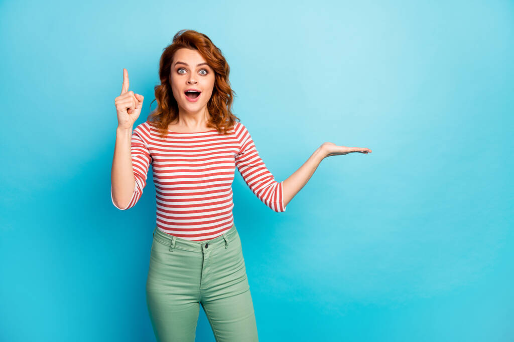 Omg its wonderful. Excited funky woman hold hand raise index finger up have incredible question answer how promote ads wear stylish white jumper isolated over blue color background - Zdjęcie, obraz