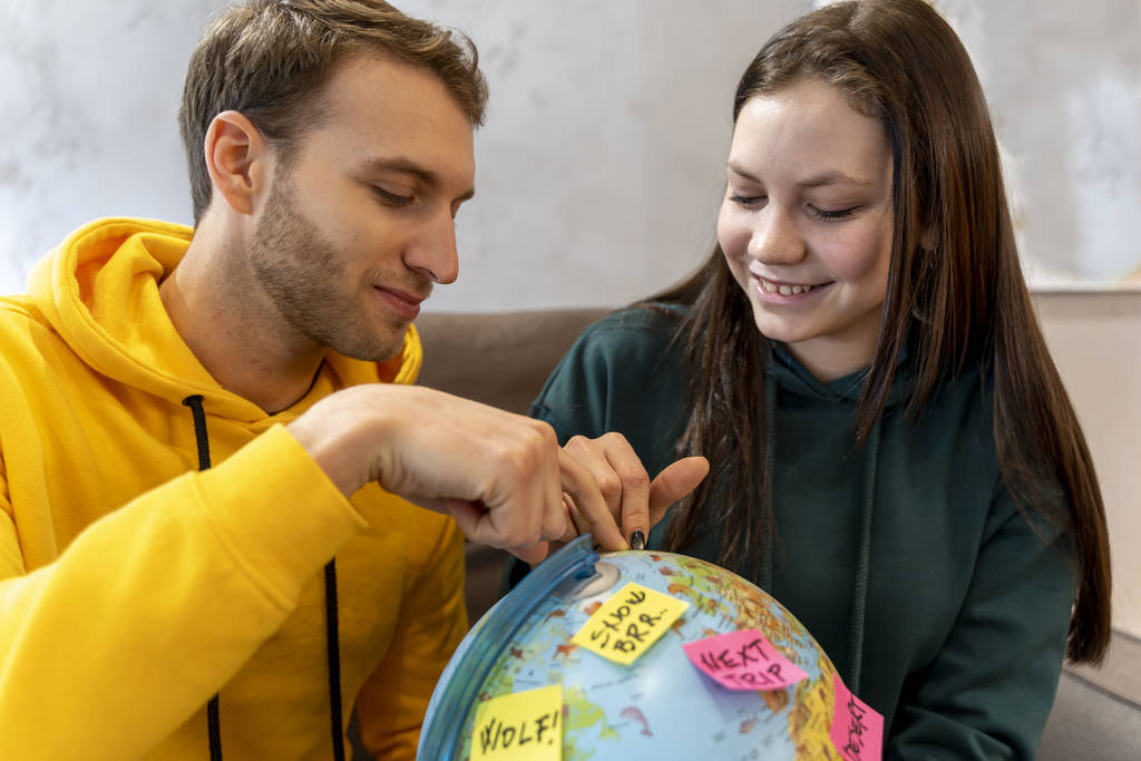 fiatal pár tervezi a következő utazás kiválasztásával a cél a világon térképen. koncepció a nyaralás a világon - Fotó, kép