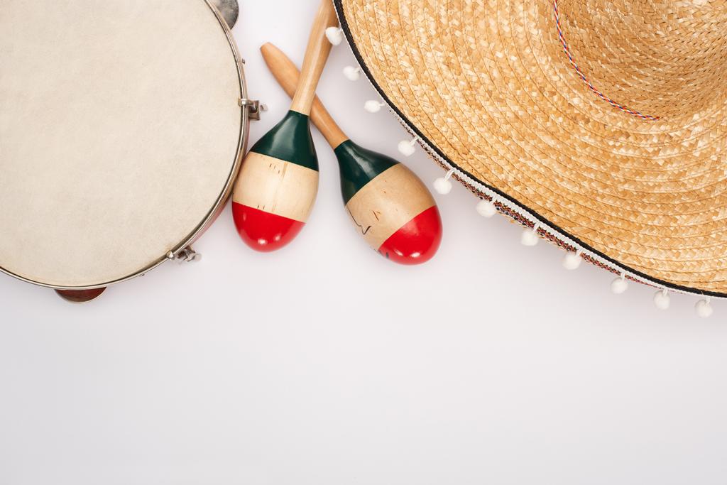 Bovenaanzicht van houten maracas met tamboerijn en sombrero op witte achtergrond - Foto, afbeelding