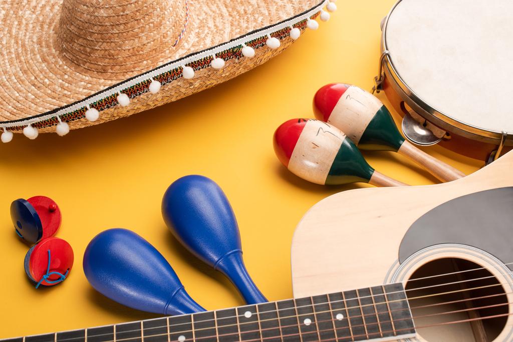 Musical instruments and mexican sombrero on yellow background - Photo, Image