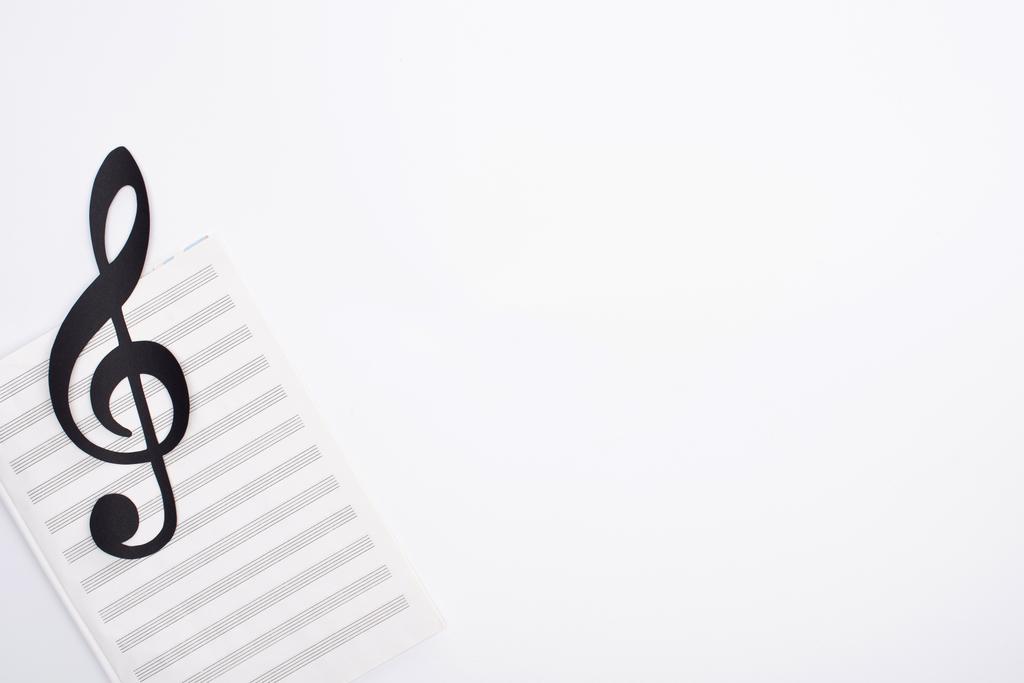 Vista dall'alto della nota di taglio di carta nera con libro di musica su sfondo bianco
 - Foto, immagini