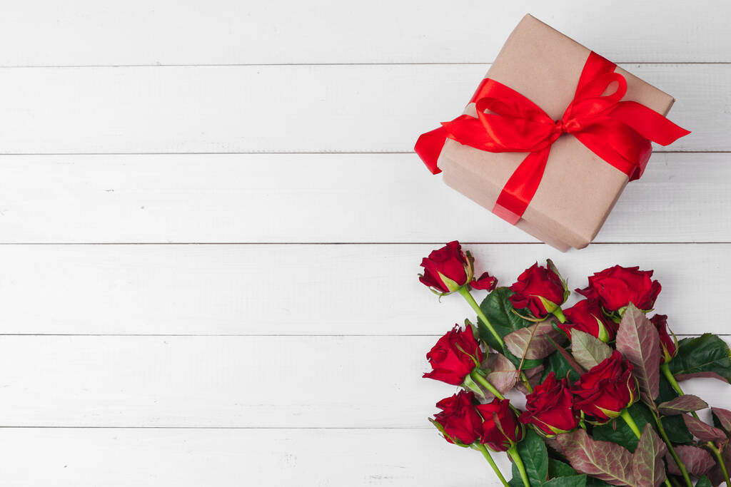 Valentinstag. Rote Rosen und Geschenkbox auf Holztisch - Foto, Bild