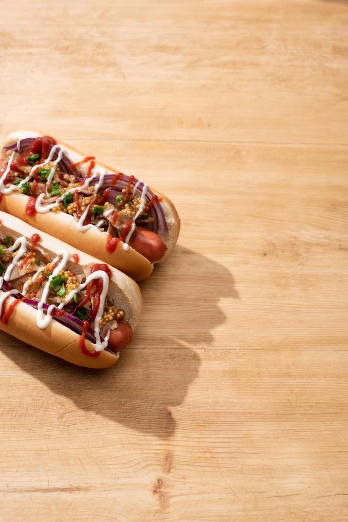 deliciosos hot dogs con cebolla roja, tocino y mostaza Dijon sobre mesa de madera
 - Foto, Imagen