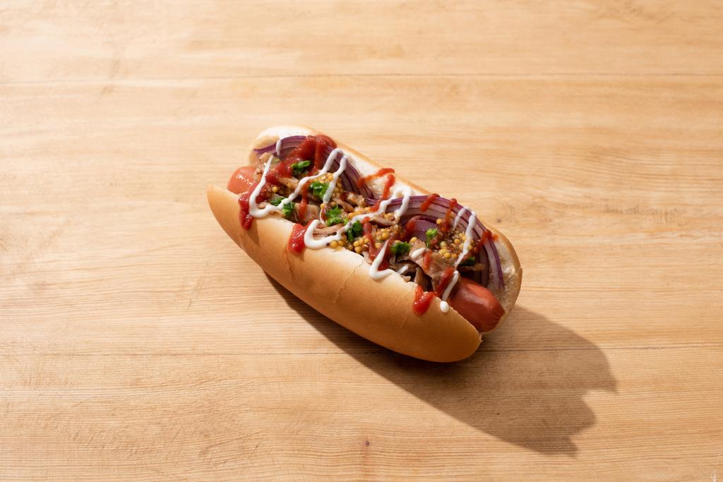 delicious hot dog with red onion, bacon and Dijon mustard on wooden table - Photo, Image
