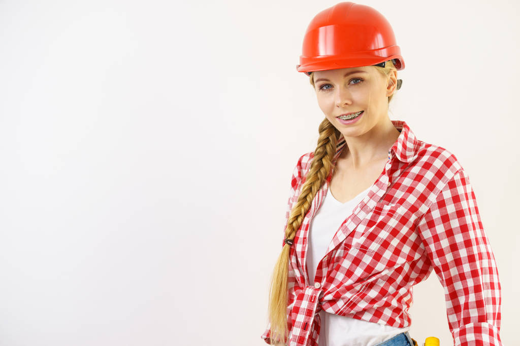 Szczęśliwy radosny kobieta noszenie kasku i kraciastej koszuli jest pozytywne opinie na temat prac budowlanych. - Zdjęcie, obraz
